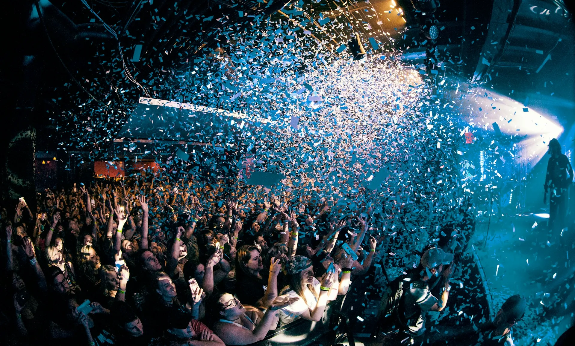 Confetti bursting over a celebrating crowd at a corporate party