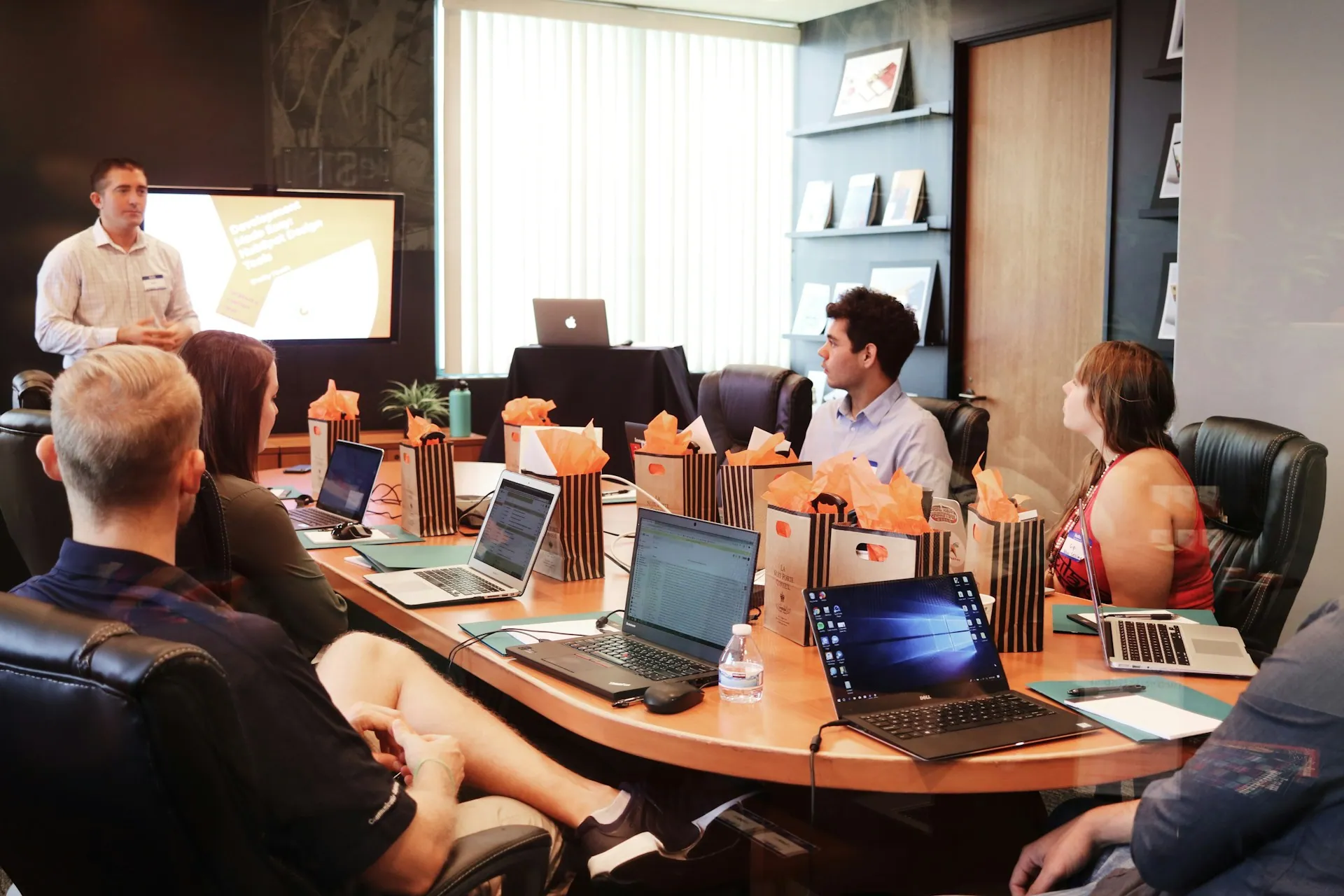 Partners seated around a boardroom table during a presentation